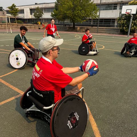 Participantes do Bootcamp 2026 praticam rugby em cadeira de rodas num campo exterior, durante uma sessão de iniciação à modalidade adaptada.