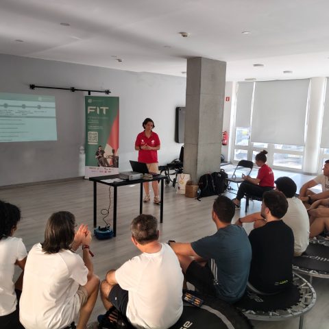 Formadora apresenta o projeto FIT - Fitness Inclusivo para Todos a um grupo de participantes durante a sessão teórica.
